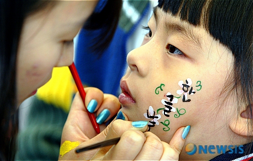 【수원=뉴시스】&nbsp; 561돌 한글날인 9일 경기 여주 세종대왕릉 주변에서 열린 세종문화큰잔치에서 한 참가자가 얼굴에 한글 페이스페인팅을 하고 있다. /강종민기자 ppkjm@newsis.com