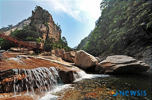 【금강산=뉴시스】&nbsp; 금강산 관광 출범 10주년을 맞은 가운데 20일 오후 여름 옷으로 갈아입은 내금강이 아름다운 자태를 뽐내고 있다.&nbsp; 금강산의 최고봉인 비로봉을 중심으로 서쪽지역을 내금강이라 부르며, 산세가 강해 남성적인 외금강과는 달리 완만하고 수려한 계곡미로 여성적인 풍경을 이룬다.&nbsp; 한편, 여름 금강산은 계곡과 봉우리에 짙은 녹음이 깔려 신록의 경치를 볼 수 있다해 봉래산(蓬萊山)이라 불린다. /이동훈기자 photoguy@newsis.com