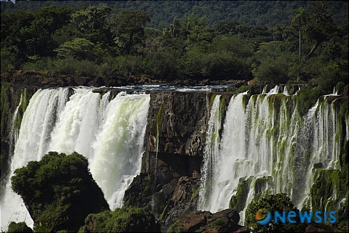 【아르헨티나=뉴시스】 이과수수폭포 [Iguazu Falls]는 브라질과 아르헨티나의 국경에 있는 폭포이다. 원어로는 CATARATAS IGUAZU, 원주민의 과라니어로 '큰물'이라는 뜻이란다 너비 4.5km. 평균낙차 70m. 너비와 낙차가 나이아가라폭포보다 크다. 브라질 파라나주(州) 남부를 흘러온 이과수강(江)이 파라나강과 합류하는 지점에서부터 36km 상류에 있으며, 암석과 섬 때문에 20여 개의 폭포로 갈라져서 갈색에 가까운 많은 양의 물이 낙하한다. 부근은 미개발의 삼림으로 뒤덮여 있으며, 폭포수와 삼림과 계곡이 아름다운 남아메리카에서 뛰어난 관광지이다. /이용남 특파원 photo@newsis.com