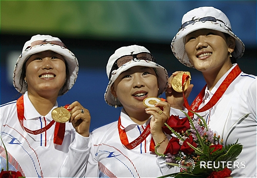 【베이징(중국)=로이터/뉴시스】 10일 오후 베이징올림픽공원 양궁장에서 열린 여자양궁 결승전에서 중국을 제치고 금메달을 딴 한국여자 양궁 대표팀의 주현정(왼쪽부터),윤옥희, 박성현이 취재진을 향해 금메달을 들어 보이고 있다.