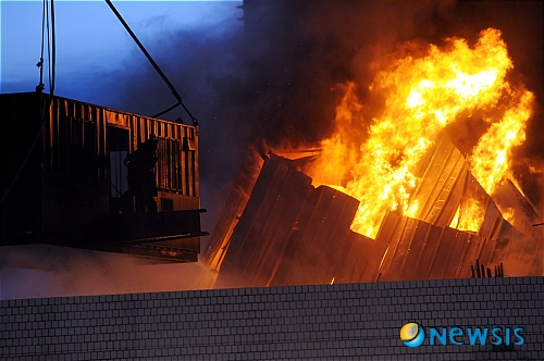 【서울=뉴시스】&nbsp; 20일 새벽 서울 용산 4구역 철거민대책위원회 회원들이 재개발에 따른 적절한 보상을 요구하며 밤샘 농성을 벌이고 있는 한강로 재개발지역의 한 건물 옥상에서 경찰의 강제 진압이 진행된 가운데 시위대가 옥상에 설치한 망루가 불에 타고 있다. /이광호기자 skitsch@newsis.com