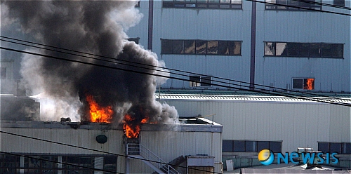 【평택=뉴시스】강종민 기자 = 쌍용자동차 공권력 투입 이틀째인 5일 경찰특공대원들이 조립 3.4공장에 진입하자 옆 건물에서 검붉은 불꽃이 일고 있다. ppkjm@newsis.com