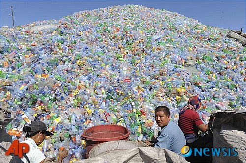 【선양(중국 랴오닝성)=AP/뉴시스】태양광 패널, 전기차에 이어 중국의 플라스틱 과잉생산이 세계에 또 다른 문제가 되고 있다는 주장이 제기됐다. 사진은 중국 랴오닝성 선양의 재활용품 야적장에서 인부들이 재활용 플라스틱 병을 분류하는 모습. 2024.07.03