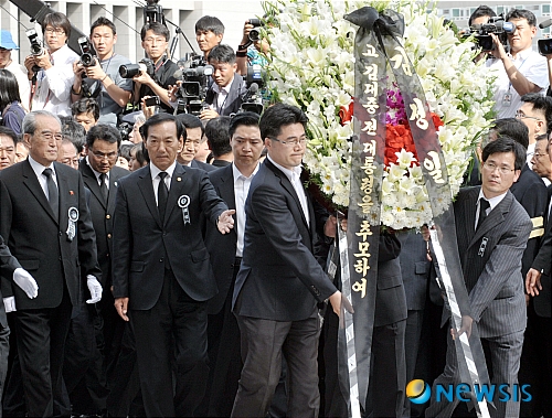 [서울=뉴시스] 사진공동취재단 = 2009년 8월21일 오후 고 김대중 전 대통령 서거 조문단으로 서울에 온 북한 노동당 김기남 비서와 통일전선부 김양건 부장이 김정일 위원장 이름의 조화를 국회분향소에 전하고 있다. photo@newsis.com 