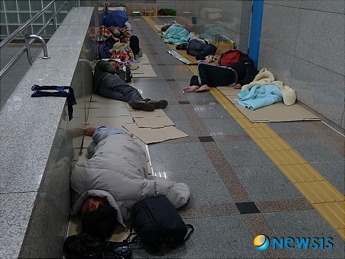 【수원=뉴시스】이승호 기자 = 8일 오전 0시15분께 수원역사 안.&nbsp; 저녁 식사 배급으로 끼니를 해결한 노숙자들이 수원역사 공중화장실 옆 통로로 자리를 옮겨 상자와 신문지를 바닥에 깔고 고된 하루를 마감한다.&nbsp; 이들에게 신종플루 예방을 위한 손 세정제나 마스크 등 위생 용품은 사치일 뿐이다. <관련기사 있음>&nbsp; jayoo2000@newsis.com