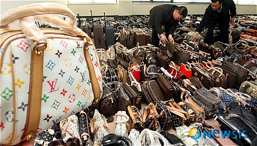 【수원=뉴시스】강종민기자 = 4일 경기 수원 경기도경찰청에서 유명상표를 도용한 일명 짝퉁 명품가방, 시계 등 2천400여점의 압수품을 경찰관계자들이 살펴보고 있다.&nbsp; ppkjm@newsis.com 