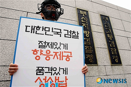 【부산=뉴시스】하경민 기자 = 지난 20일 방영된 MBC 'PD수첩'에서 건설업자가 검사들을 접대했다고 주장하면서 '상납 일지'를 폭로해 파문이 일고 있다.&nbsp; 21일 오전 부산지검 정문에서 한 대학생이 야구 심판용 마스크를 착용한 채 방송내용을 규탄하는 1인 시위를 벌이고 있다.&nbsp; yulnetphoto@newsis.com