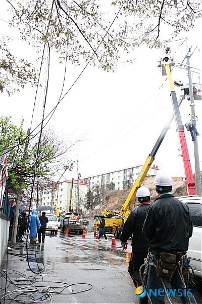 【춘천=뉴시스】신형근 기자 = 21일 오후 3시께 강원 춘천시 효자동 춘천우체국 뒤에 세워져 있던 전신주 3개가 잇따라 넘어지면서 인근 수백 가구의 전력공급이 끊겨 주민들이 큰 불편을 겪고 있다. 사진은 비상복구반이 긴급 투입돼 임시 복구작업을 펼치고 있는 모습. shk@newsis.com