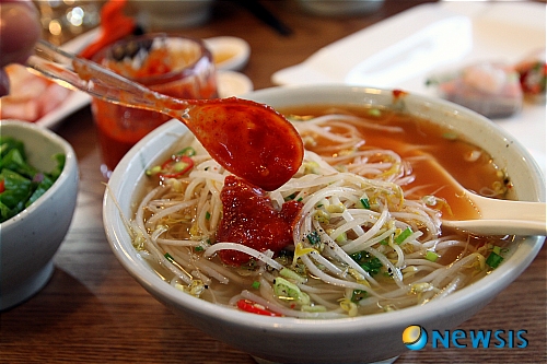 【서울=뉴시스】김조수의 맛있는 집 = “부장님, 쌀국수 먹죠?”(여직원들), “싫어. 칼국수나 먹자.”(부장 이하 남자직원들) 회사의 점심 시간에 흔히 접할 수 있는 풍경이다. 다이어트 건강식으로 쌀국수를 선호하는 여성과 달리 남성, 특히 기성세대는 쌀국수라면 손사래를 친다. 밀가루로 만든 국수에 비해 너무도 비싼 가격과 특유의 강한 맛 때문이다. 그래서일까, 베트남 쌀국수는 도입되기 시작했던 2000년대 초반에 비해 오히려 뒷걸음질 치고 있다. 하지만 서울 명동 일대 직장인들 사이에서는 다르다. 베트남 쌀국수가 당당히 점심 메뉴로 자리 잡았다. 지하철 4호선 명동역 8번 출구 앞 훼미리마트를 끼고 좌회전, 70m쯤 직진하다 베이직하우스와 충무김밥 사이 막다른 골목 안쪽의 왼쪽 건물 2층에 터를 잡은 ‘싸이퍼(Psypho) 디 오리지널’(070-8868-0424)은 100석이나 되지만 점심무렵이년 한참을 기다려야 할 정도로 붐빈다. 50대 중반의 남성 상사와 20대 중반의 여성 신입사원이 어울려 쌀국수를 즐기는 모습이 흔하다. 인기 요인이 뭘까. 일단 가격부터 ‘착하다’. 가장 일반적인 쌀국수라 할 수 있는 퍼 오리지널이 미디엄5900원, 엑스라지 7900원이다. 유명 프랜차이즈 쌀국수집의 7000원~1만원대에 비해 20% 가량 저렴하다. 여기에 숙주를 비롯한 신선한 야채가 듬뿍 들어간 비빔밥도 준다. 한 마디로 1석2조인 셈이다. 맛도 좋다. 처음 국물 맛을 봤을 때 그 짭조름한 맛이 지금까지 먹어온 쌀국수 국물 맛과는 전혀 달랐다. 그런데 면과 함께 먹으니 처음의 짠맛은 온데간데 없이 사라지고 진한 사골 육수 맛이 입 안에 흘러 넘친다. 심심한 면 맛에 국물 맛이 자연스럽게 배어들었다. 이 집이 자랑하는 베트남 전통 조리공정에 따라 만든 육수가 빛을 발하는 순간이다. 인공화학식품 첨가물과 액상조미료를 배제하고 많은 양의 사골과 양지를 12시간 끓여 제대로 된 육수를 만든다. 또 대부분의 쌀국수 집에서 손님 취향과 상관 없이 알아서 넣어 내오는 고수(실란트로)를 따로 주므로 취향에 맞춰 넣을 수 잇다. 국물에서 독한 냄새나 강한 맛이 없는 이유다. 부드럽게 술술 넘어갈 수밖에 없다. 향을 내기 위해 넣는 레몬 즙도 전용 기구로 쉽게 짤 수 있게 했다. 또 다른 쌀국수 메뉴로 퍼 사이퍼가 있다. 미디엄 7900원, 엑스라지 9900원으로 오리지널보다는 다소 비싸지만 비법 양념을 해 숯불에 구운 쇠고기 등심이 곁들여진다. 쌀국수, 육수 등과 어우러지면서 독특한 풍미를 이끌어 내 큰 인기다. 주인 박정걸(39)씨가 베트남 하노이 새벽시장에서 맛으로 소문난 쌀국수 노점상의 메뉴에서 영감을 얻어 자체 개발한 메뉴다. 사이드 메뉴로 넴 잔(2피스 4000원)이 있다. 북부 하노이식 정통 베트남 튀김만두로 돼지고기, 버섯, 잡채, 당근 등을 라이스 페이퍼에 말아 튀긴 요리다. 당일 들여온 질 좋은 식자재로 베트남인 직원이 매장에서 튀겨 만들므로 중국산 냉동 밀가루 춘권과는 비교조차 무의미하다. 내가 강력히 추천하는 메뉴다. 흔히 월남쌈이라고 하는 고이꾸온(3피스 5000원)은 새우, 쇠고기, 야채, 파인애플, 양파, 당근, 오이 등을 라이스 페이퍼에 싸서 먹는 다이어트 음식이다. 신선한 고급 식재료로 만들어 더욱 안심이 된다. 숯불 쇠고기 등심 바비큐 월남쌈 세트라는 긴 이름의 메뉴는 술 안주로 제 격이다. 숯불에 구운 소고기 등심과 새우, 야채, 라이스 페이퍼가 함께 나온다. 싸 먹으면서 술잔을 기울일 수 있어 좋다. 3명이 먹기에 충분할 정도로 양이 풍성하다. 가게 이름인 사이퍼는 퍼(쌀국수)에 미쳤다는 뜻이다. 그만큼 열심히 정성껏 진짜 쌀국수를 만들어 보겠다는 주인의 신념이 담긴 간판이다. 주인 박씨는 국내 대기업에 다니다 베트남 출장길에 맛을 본 정통 쌀국수의 맛을 잊지 못해 퇴사했다. 아예 베트남으로 건너가 3년 가까이 하노이대에서 유학까지 하며 300여 곳에 달하는 이름난 쌀국수집을 돌며 1000여회 넘게 식사를 하면서 진짜 쌀국수 맛을 찾았다. 이렇게 친분을 쌓은 맛있는 집들에서 일까지 도우며 전수 받은 비법들을 들고 돌아와 반년 전 오픈했다. 모든 손님에게 먹는샘물 1병과 후식으로 커피, 녹차 등을 제공한다. 오전 11시30분에 문을 열어 오후 9시에 라스트 오더를 받는다. 문 닫는 시간은 손님이 갈 때까지다. 연중무휴다./외식저널리스트 foodreporter@yahoo.co.kr