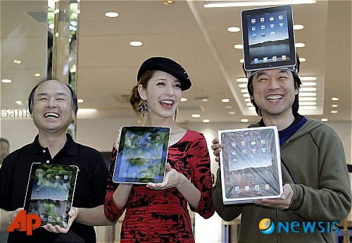 【도쿄=AP/뉴시스】28일 아이패드가 일본 시장에 공식 출시된 가운데 도쿄 하라주쿠에 위치한 소프트뱅크 매장에서 아이패드 1호 구입자 카즈키 미우라(오른쪽)이 마사요시 손 소프트뱅크 회장(왼쪽)과 모델 리나 후지이(가운데)와 함께 포즈를 취하고 있다.