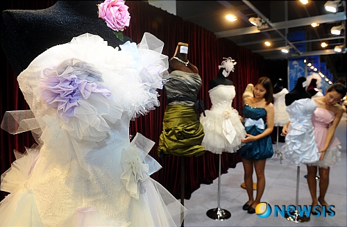 【서울=뉴시스】서재훈 기자 = 25일 오전 서울 양재동 aT센터에서 '2010 추계 결혼박람회'가 열린 가운데 전시장 도우미들이 웨딩드레스를 살펴보고 있다. 기간은 25일부터 27일까지.&nbsp; jhseo@newsis.com