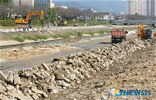 【정읍=뉴시스】신홍관 기자 = 익산지방국토관리청이 시행하고 있는 정읍천 생태하천 조성공사를 위해 당초 깔려있던 콘크리트를 걷어내고 있다. 이 폐콘크리트는 다시 재활용 처리 후 '순환골재'로 공사 현장에 사용하고 있어 수질 오염 원인이 되고 있다. <관련기사 있음>&nbsp; shong@newsis.com