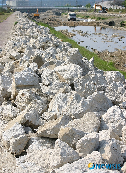 【정읍=뉴시스】신홍관 기자 = 익산지방국토관리청이 시행하고 있는 정읍천 생태하천 조성공사를 위해 당초 깔려있던 콘크리트를 걷어내고 있다. 이 폐콘크리트는 다시 재활용 처리 후 '순환골재'로 공사 현장에 사용하고 있어 수질 오염 원인이 되고 있다. <관련기사 있음>&nbsp; shong@newsis.com