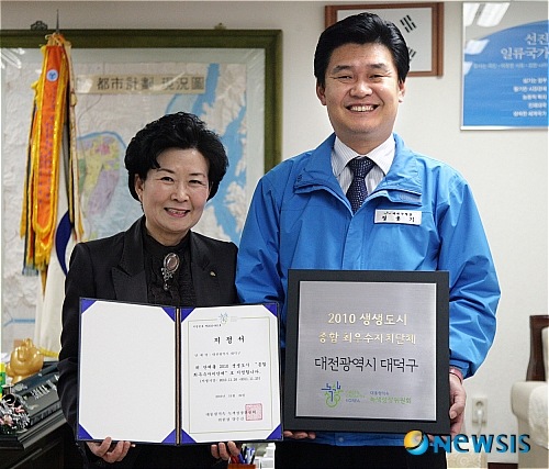 【대전=뉴시스】박희송 기자 = 대전 대덕구(구청장 정용기)가 대통령직속 녹색성장위원회가 주최하고, 행정안전부와 지식경제부, 환경부에서 후원한 2010 생생도시(EcoRich City) 대통령표창을 6일 수상한다. 사진은 조영옥 청소위생팀장과 정용기 대덕구청장(오른쪽)이 생생도시 지정서와 현판을 들어보이고 있다. (사진=대전 대덕구청 제공) photo@newsis.com