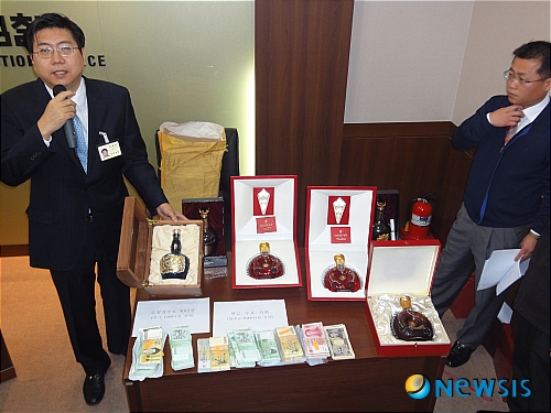 【성남=뉴시스】김기중 기자 = 20일 수원지검 성남지청에서 열린 이대엽 전 성남시장 일가 비리 수사 브리핑에서 이 전 시장 자택에서 압수한 3000만원 가량의 미화 등 8000만원의 현금과 싯가 500만원 상당의 루이13세 꼬냑 3병, 싯가 1200만원 상당 로얄살루트 50년산 1병 등이 증거물로 공개되고 있다.&nbsp; k2j@newsis.com