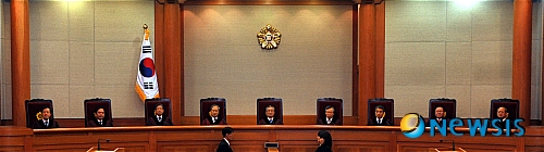 【서울=뉴시스】전진환 기자 = 28일 오후 서울 종로 재동 헌번재판소 대심판정에 인터넷에 허위 내용의 글을 게재하면 처벌하도록 한 전기통신기본법 조항이 헌법상 표현의 자유를 침해한다며 '미네르바'박대성씨가 낸 헌법소원에 대한 판결을 위해 이강국 헌재소장과 재판관들이 자리하고 있다.&nbsp;&nbsp; amin2@newsis.com