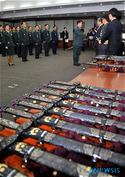 【서울=뉴시스】전진환 기자 = 31일 오전 장성 진급신고식이 열린 서울 용산구 국방부 대회의실에서 김관진 국방부장관이 준장 진급장에게 삼정도를 수여하고 있다.  amin2@newsis.com 