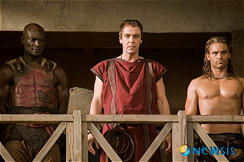 【서울=뉴시스】김정환 기자 = 미국 드라마 ‘스파르타쿠스’의 새 시즌이 시즌1 방송 1년만에 국내 상륙한다.&nbsp;&nbsp; ‘스파르타쿠스: 갓 오브 아레나’(60분물 6부작 HD 시리즈·19세 이상 시청가)라는 이름으로 찾아오는 새 시즌은 케이블 유료채널 캐치온을 통해 26일부터 토요일 자정 2편 연속으로 3주간 ‘무삭제 버전’으로 방송된다. 이어 영화채널 OCN에서 3월11일부터 금요일 자정 1편씩 6주간 전파를 탄다. 3월2일 캐치온 디맨드를 통해 시즌1과 새 시즌 모두를 VOD로 볼 수 있다.&nbsp; ‘스파르타쿠스’는 영화 ‘스파이더맨’의 샘 레이미 감독과 할리우드 제작자 로브 태퍼트가 공동 제작한 스펙터클 액션시리즈다.&nbsp; 고대 로마시대 전설적인 검투사 스파르타쿠스의 사랑과 복수를 감각적인 영상으로 그려낸 시즌1은 출연진이 스타덤에 오르고, 스마트폰 게임과 만화영화로 출시되는 등 세계적인 화제를 모았다. 지난해 국내 방송 당시 16주 연속 포털 미국드라마 검색어 1위, 국내 미국드라마 사상 최고시청률을 경신했을 정도로 주목받았다.&nbsp; 시즌2는 미국 유료 케이블채널 스타스에서 지난달 21일 방송을 시작한 이래 시청자 280만명을 TV 앞으로 모으며 미국 케이블TV 시청률 1위를 기록했다. 국내 역시 정식 방송 전임에도 포털사이트에 6주 연속 미드 랭킹 1위에 오르면서 기대감을 더하고 있다.&nbsp; ‘스파르타쿠스: 갓 오브 아레나’는 시즌 1의 이전 내용을 담은 ‘프리퀄’ 스토리다.&nbsp; 스파르타쿠스 등장 이전으로 시점이 돌아가 스파르타쿠스를 잔혹한 노예 검투사로 만든 훈련소 주인 바티아투스(존 해너)와 아내 루크레시아(루시 로리스)가 최고의 검투사 집안으로 성장해가는 과정을 스펙터클한 액션서사로 풀어낸다.&nbsp; 또 스파르타쿠스와 대립각을 세웠던 챔피언 검투사 크릭수스(마누 베넷), 냉혹한 교관 오네노마우스(피터 멘사) 등 시즌1에서 활약한 주요 인물들의 과거 이야기와 현란한 액션이 압권이다.&nbsp; 시즌1에서 검증된 충격 액션과 감각적인 성(性) 묘사, 웅장한 영상미를 그대로 살리면서 권력과 야망을 향한 피비린내 나는 검투사들의 대결, 귀족들의 계략과 음모, 고대 로마의 사랑과 탐욕들을 더욱 파격적으로 그려내 볼거리를 선사한다.&nbsp; 고대 로마의 검투장에 와 있는 것처럼 느끼게 하는 리얼한 카메라 기법, 화려한 CG 효과, 한층 업그레이드 된 그래픽노블(만화)적인 연출력, 더욱 팽팽해진 긴장감, 숨 가쁠 정도로 빠른 전개 등으로 미국 현지에서 ‘시즌1 방송 전에 이미 기획된 것 아니냐’는 반응이 나올 정도로 스토리 완성도와 영상미에서 시즌 1을 능가한다는 평가를 받고 있다.&nbsp; 특히 시즌1에서 ‘스파르타쿠스’ 역을 맡은 앤디 위필드의 바통을 이어받은 바티아투스가의 핵심 검투사 가니쿠스(더스틴 클레어)가 등장해 다시 짐승남 붐을 일으킬 태세다.&nbsp; OCN과 캐치온은 “시즌1이 종영되면서부터 시즌2에 대한 문의가 계속될 정도로 팬들의 관심이 폭발적이었다”며 “이번 프리퀄 시즌 또한 성인시청자들을 위한 최고의 볼거리가 될 것”이라고 자신했다.&nbsp; ace@newsis.com