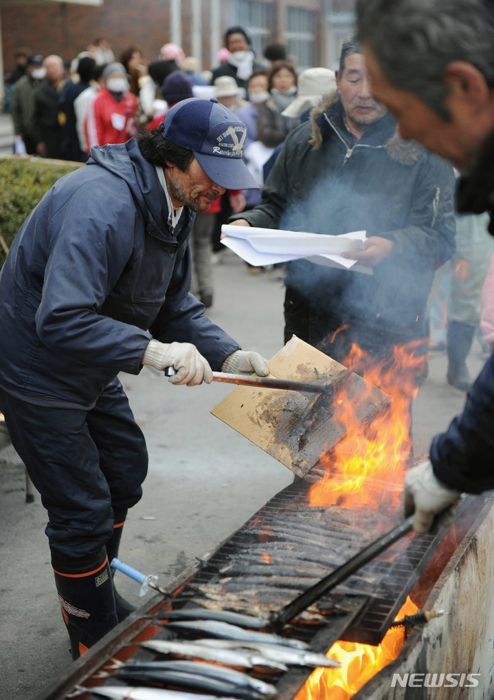 [오나가와(일본)=AP/뉴시스]엄청난 규모의 지진과 쓰나미가 발생하 며칠 뒤인 2011년 3월20일 일본 미야기(宮城)현 오나가와(女川)에서 주민들이 피난민들에게 지역 별미로 인기 있는 꽁치구이를 제공하고 있다. 지난해 일본의 수산물 생산량은 고등어, 가다랑이, 꽁치 등의 어획량 저조로 처음으로 400만t을 밑돌며 1955년 통계 작성 이래 사상 최저 기록을 경신했다고 NHK가 30일 보도했다. 2023.05.30.