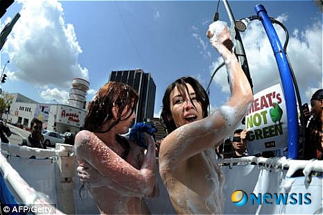 【서울=뉴시스】동물보호단체 '페타(PETA)' 소속 여성 모델 2명이 지난 22일 세계 물의 날을 맞아 미국 로스앤젤레스에서 채식주의 캠페인의 일환으로 누드 길거리 샤워 퍼포먼스를 펼치고 있다. (사진출처=영국 메트로 웹사이트)