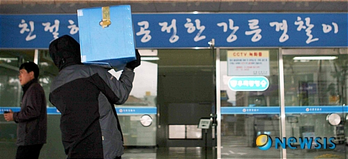 【강릉=뉴시스】김경목 기자 = 22일 강원 강릉경찰서에서 엄기영 한나라당 강원도지사 후보측 선거운동원들의 불법 선거운동 현장을 적발한 가운데 수사관이 현장에서 압수한 증거물을 사무실로 옮기고 있다.&nbsp; photo31@newsis.com