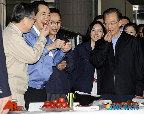 【후쿠시마(일본)=AP/뉴시스】이명박 대통령(왼쪽 세번째)과 원자바오 중국 국가주석(오른쪽)이 21일 후쿠시마현 후쿠시마를 방문해 간 나오토 총리와 함께 현지 생산 토마토를 시식하고 있다.