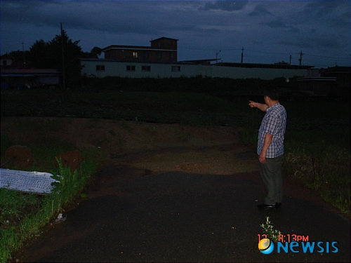 【당진=뉴시스】박상록 기자 = 충남 당진군 합덕읍 운산리 한 주민이 매립된 구 아스팔트 포장 도로 현장을 가리키며 불만을 나타내고 있다. park2223@newsis.com 