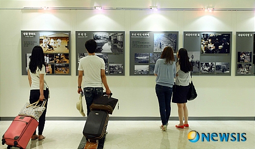 【부산=뉴시스】 하경민 기자 = 부산 롯데호텔은 호텔 레스토랑 새단장 공사로 인해 생긴 벽면에 미술작품 등을 전시하는 갤러리로 조성했다. 20일 오전 호텔 로비에 조성된 갤러리에서 고객들이 '1953~54년 컬러사진으로 본 부산'이라는 사진전을 관람하고 있다. yulnetphoto@newsis.com
