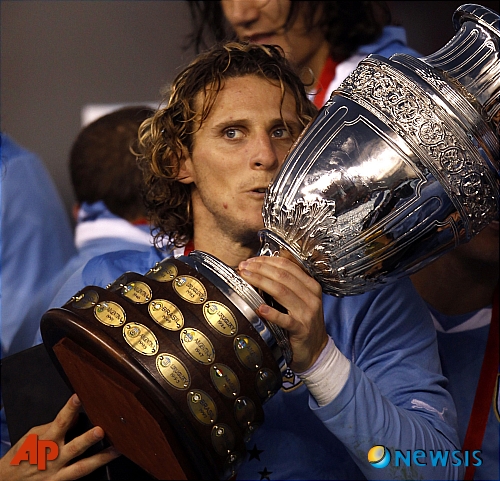 【부에노스아이레스(아르헨티나)=AP/뉴시스】우루과이가 24일(현지시각) 아르헨티나 부에노스아이레스에서 2011 코파 아메리카컵 파라과이와의 결승전에서 파라과이를 3-0으로 물리치고 통산 15번째 우승을 차지했다.&nbsp; 우루과이는 디에고 포를란의 2골과 수아레스의 1골을 묶어 파라과이에 3-0 승리를 거두며 우승을 차지했다.&nbsp; 디에고 포를란이 우승컵을 들고 포즈를 취하고 있다.&nbsp; 