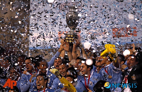 【부에노스아이레스(아르헨티나)=AP/뉴시스】우루과이가 24일(현지시각) 아르헨티나 부에노스아이레스에서 2011 코파 아메리카컵 파라과이와의 결승전에서 파라과이를 3-0으로 물리치고 통산 15번째 우승을 차지했다.&nbsp; 우루과이는 수아레즈의 선제골과 디에고 포를란의 2골을 묶어 파라과이에 3-0 승리를 거두며 우승을 차지했다.&nbsp; 우루과이 선수들이 우승컵을 들고 환호하고 있다. 