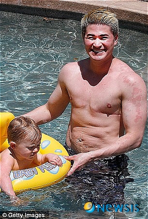 【서울=뉴시스】세계 최초로 '임신한 남성' 토머스 비티(37)가 3명의 자식을 낳은 후 다시 근육질의 몸매를 회복했다. 비티가 지난해 낳은 막내아들 옌스를 데리고 수영장에서 물놀이를 하고 있다. (사진 출처 : 英 데일리 메일 웹사이트)