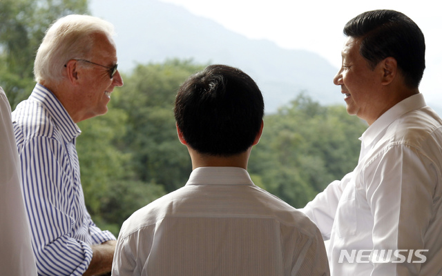 U.S. Vice President Joe Biden, left, talks with Chinese Vice President Xi Jinping, right, as they visit the South Bridge that's part of an ancient irrigation system in Dujiangyan on the outskirts of Chengdu, in southwestern China's Sichuan province, Sunday, Aug. 21, 2011. (AP Photo/Ng Han Guan)