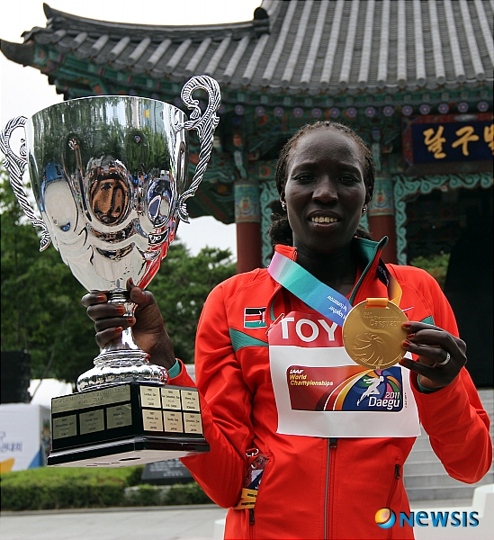 【대구=뉴시스】박종민 기자 = 2011 대구세계육상선수권대회가 개막한 27일 오전 여자 마라톤 시상식이 열린 대구 국채보상운동공원에서 2시간 28분 43초로 금메달을 획득한 에드나 키플라갓이 단체전 트로피와 금메달을 들고 기뻐하고 있다.&nbsp; jmc@newsis.com
