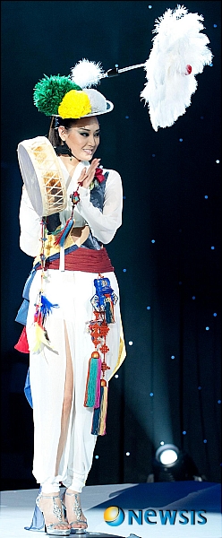 【서울=뉴시스】신동립 기자 = 2010 미스코리아 진 정소라(20·고려대 국제어문학부1)의 파격 전통패션이 주목받고 있다.&nbsp; 2011 미스유니버스 선발대회에 참가 중인 정소라는 7일 브라질 상파울루 크레디카드 홀에서 주관방송사인 미국 NBC TV가 녹화한 미스유니버스 전통의상 쇼에 북을 든 농악 한복차림으로 등장했다. 국제미인뽑기대회에 나선 역대 미스코리아가 입은 조선의 왕비 또는 기생 패션이 아니었다.&nbsp; 이 풍물놀이 옷은 퍼레이드 때 입기로 돼있었다. 대회 프로그램이 바뀌면서 전통옷을 선보일 기회가 한 번으로 줄자 정소라는 함께 준비해간 소례복 당의 대신 이것을 택했다.&nbsp; 정소라의 변종 농악대원복은 얇고 비치는 소재의 홑저고리, 말군 바지, 거들 치마, 바지, 등걸이 배자를 응용한 조끼로 이뤄졌다. 허리선이 드러난 짧은 홑저고리와 조끼, 그리고 바지의 트임으로 신비로운 분위기를 강조했다.&nbsp;&nbsp; 당초 거리 행진을 염두에 둔만큼 액세서리들도 화려하다. 개최국 브라질 국기의 3색 꽃과 타조털 부포를 단 상모, 노리개와 귀주머니 등은 매듭 기능전수자 심영미(65)씨와 자수 명장 이승희(54)씨의 작품이다.&nbsp;&nbsp; 정소라에게 이 옷을 지어준 한복 패션디자이너 김은경(42·은채)씨는 "상모 아이디어를 낸 정소라의 뜻에 맞춰 한국적인 오방색, 농악의상을 모티브로 현대적인 해석을 시도해 한복의 모던한 세련미를 강조했다"면서 "미스유니버스의 콘셉트가 섹시 쪽으로 흐르는 트렌드로 감안했다"고 밝혔다. "정형화된 한복 특유의 색상에서 벗어나 세련되고 다양한 색감을 보여주고, 한복 역시 때와 장소에 따라 창조적인 변화가 가능한 옷임을 알려주고 싶었다"는 것이다.&nbsp; 정소라는 12일 추석 밤 9시(현지시간) 크레디카드홀에서 제60회 미스유니버스 타이틀을 놓고 각국 대표미녀 88명과 경염한다.&nbsp; reap@newsis.com&nbsp;&nbsp; 