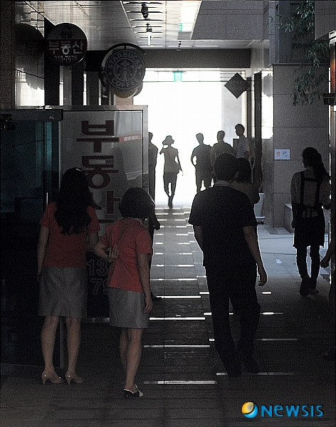 【서울=뉴시스】박종민 기자 = 15일 오후 늦은 더위로 전력 수요가 일시에 몰리면서 전국적으로 곳곳에 정전 사태가 일어나 시민들이 큰 불편을 겪고 있는 가운데 서울 마포구 한 건물의 입주민들이 정전으로 인해 냉방이 중단되어 삼삼오오 건물 밖으로 나오고 있다.&nbsp; jmc@newsis.com