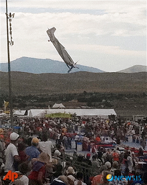 【리노(미 네바다주)=AP/뉴시스】지난 16일(현지시간) 미 네바다주 리노에서 열린 내셔널 챔피언쉽 에어 레이스 대회에서 지미 리워드가 조종하는 P51 무스탕기가 관중들을 향해 추락하고 있다. 이 사고로 조종사를 포함해 모두 9명이 숨지고 54명이 부상했다. 하지만 리워드는 마지막 순간에 더 많은 사람들이 사망하는 것을 막기 위해 많은 생명을 구했다는 이유로 영웅으로 추앙되고 있다.