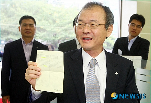 【부산=뉴시스】 하경민 기자 = 이승우 예금보험공사 사장이 19일 오후 부산 부산진구 토마토2저축은행을 방문, 예금주들을 안심시키기 위해 2000만원짜리 1년 만기 정기예금 통장을 만든 뒤 통장을 들어보이고 있다.&nbsp; yulnetphoto@newsis.com 