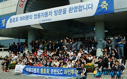 【서울=뉴시스】쌍용자동차가 24일 카이런 및 코란도C 동호회 회원 150여명을 평택 공장에 초청해 공장견학을 실시했다. 행사에 참석한 동호회 회원 150여명이 코란도C 생산라인 견학을 마치고 쌍용차 평택공장 본관 앞에서 기념 촬영하는 모습.(사진 = 쌍용차 제공) photo@newsis.com