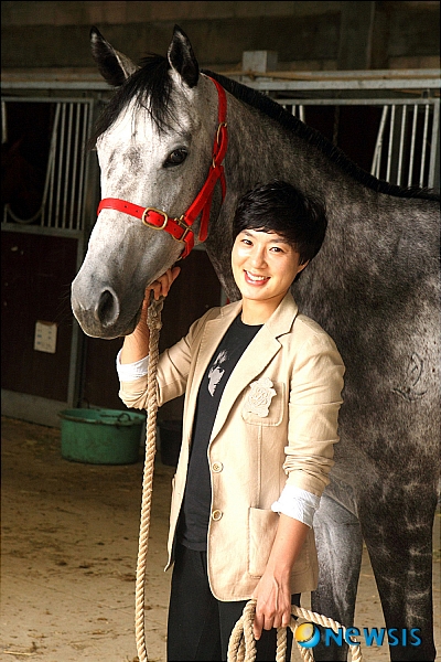 【과천=뉴시스】진현권 기자 = 지난 7월 데뷔한 이신영 조교사는 데뷔 3개월 만에 6승을 거둬 승률 33%를 기록 중이다. 이 조교사는 한국경마의 유망주로 떠오른 김혜선 기수와 한조를 이뤄 연승을 하며 우먼파워를 선보이고 있다. 29일 경주마와 함께 포즈를 취하고 있는 이 조교사. (사진=한국마사회 제공) photo@newsis.com 
