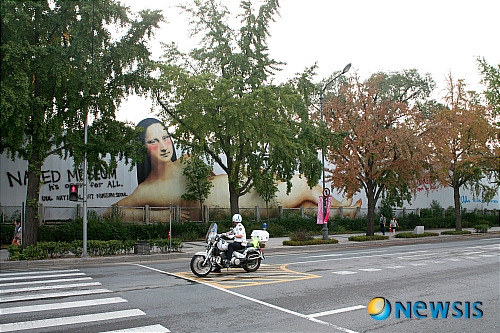 【서울=뉴시스】유상우 기자 = 국립현대미술관이 서울 종로구 소격동에 건립 중인 국립현대미술관 서울관의 이름을 'UUL 국립서울미술관'으로 결정했다.  "'UUL'은 '우리'의 줄임말이자 서울의 '울'과 울타리의 순우리말로 '언제나 우리 곁에 있는 우리들의 미술관'이라는 의미"라며 "높은 벽으로 둘러 쌓여 있는 공간이 아닌, 언제나 열려 있는 예술과 문화의 울타리라는 미술관에 대한 새로운 정의와 역할을 담고 있다"고 설명했다.  국립현대미술관은 UUL국립서울미술관의 공사장 가림막을 현대미술작품 전시공간으로 탈바꿈시켰다.  지난해 첫번째 아트 펜스 프로젝트로 작가 정서영씨의 작품을 설치한 데 이어 올해는 광고계에서 두각을 나타내고 있는 이제석씨의 작품으로 꾸몄다. 미술관 내외부 공간의 현장 제작 설치작품이 순수 예술가에 의해 제작되기는 했으나 광고전문가의 작품으로 벽면을 꾸미는 것은 이례적이다.  국립현대미술관은 "현시대의 광고가 팝 아트와 같이 대중과 적극적인 소통을 가능케 하는 현대 미술의 한 장르로 인식되고 있다"며 "세계적인 광고 대회를 휩쓸며 화제가 된 이제석의 파격적이고 창의적인 정신이 앞으로 미술관이 나아가야 할 파괴, 탈피, 혁신적인 이미지에 걸맞다고 판단했다"고 전했다.  아트 펜스는 주제 구역에 따라 두 가지로 나뉜다.  미술관 정문을 중심으로 좌우로 길게 나열된 가림막에는 미술관의 오픈을 티저 형식으로 알리는 '벌거벗은 미술관(Naked Museum)'이 전시된다. 코너를 돌아 오른쪽으로 꺾어지는 측면 벽면에는 '이게 정말 한국이야?(Amazing Korea)'가 설치된다. 외국인 관광객에게 눈부시게 발전한 한국을 홍보하는 작품이다.  국립현대미술관은 "대중에게 놀라움과 파격의 모습을 보여주는 현대미술의 전형적인 이미지이자 대중을 향해 권위와 위엄을 벗어던지고 친근하게 다가서는 'UUL국립서울미술관'의 미래를 상징적으로 보여준다"고 밝혔다.  'UUL국립서울미술관'은 10월 말 북촌로길에 접해있는 미술관 대지에 팝업 스토어를 설치해 UUL문화상품 판매와 2013년 개관할 미술관의 모습을 볼 수 있는 공간을 마련할 예정이다.  'UUL국립서울미술관' 새 이름의 탄생을 시민과 같이 축하하기 위해 인사동에서부터 UUL까지 극단 몸꼴이 연출하는 퍼포먼스를 30일부터 10월2일까지 펼친다. 또 서울스퀘어빌딩 미디어캔버스에 UUL의 탄생을 알리는 작품을 상영하고, 광고 영상작품 공모제를 개최할 예정이다. www.uul.go.kr 02-2188-6000  swryu@newsis.com 