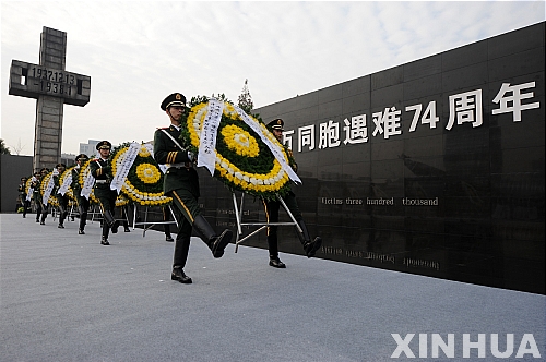 【난징=신화/뉴시스】13일 중국 장쑤(江蘇)성 난징에서 인민해방군 소속 군인들이 난징 대학살 74주년을 맞아 희생자들을 기리기 위한 화환을 옮기고 있다. 역사 기록에 의하면 난징대학살 기간 동안 중국의 민간인과 군인 등 30만 명의 희생자가 발생한 것으로 알려졌다.