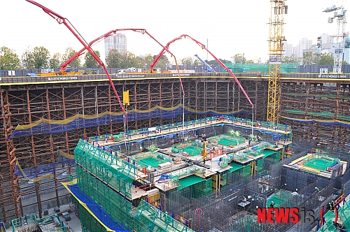 【서울=뉴시스】서상준 기자 = 롯데건설은 공사기간 단축 및 원가절감을 위해 현재 공사중인 롯데월드타워에 '거푸집 시스템'공법을 적용하고 있다고 15일 밝혔다.&nbsp; ACS는 거푸집과 거푸집 작업을 위한 발판으로 구성되어 있는 시스템 폼(System Form)으로서, 자체 발판에서 모든 거푸집 작업과 철근 작업, 콘크리드 작업이 가능하다. 또 타설 후 다음 위층까지 유압 시스템으로 자동 인양되기 때문에 안전 시공은 물론 공기 단축까지 가능한 획기적인 공법이다.&nbsp; 롯데월드타워 공사 현장. (사진 = 롯데건설 제공)&nbsp; ssjun@newsis.com