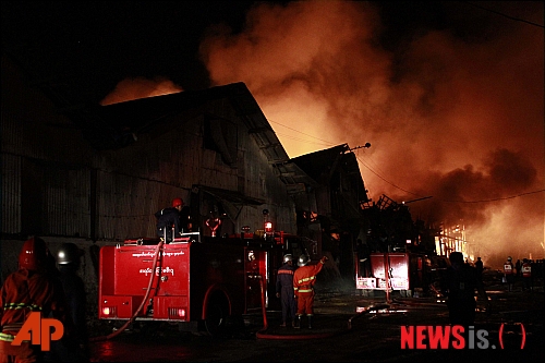 【양곤=AP/뉴시스】29일 양곤 동부한 창고에 불이 나 연기와 화염이 솟아오르고 있다. 당국은 이 화재로 최소 10여 명이 숨졌을 것으로 보고 있다.