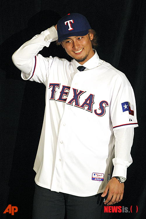 New Texas Rangers pitcher Yu Darvish displays his new jersey during a baseball news conference at Rangers Ballpark in Arlington, Texas, Friday, Jan. 20, 2012. The introduction came two days after Darvish and the Rangers agreed to a six-year contract. (AP Photo/LM Otero)