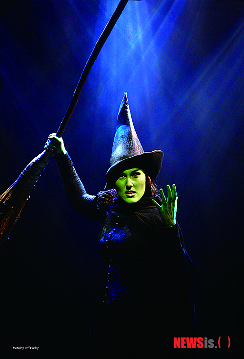 【싱가포르=뉴시스】이재훈 기자 = 수천개의 비눗방울을 뿌리는 버블머신, 무대 꼭대기에 설치된 소형 비행기 크기의 길이 6m짜리 드래건 머신, 10m가량 하늘로 치솟는 플라잉….&nbsp; 뮤지컬 '위키드'는 과연 블록버스터 뮤지컬이었다. 2시간45분의 러닝타임 동안 무대가 54번이 바뀌고 조명의 큐사인은 594번이나 들어간다.&nbsp; 그러나 무엇보다 이 뮤지컬의 방점은 촘촘하게 짜인 이야기다. 미국의 동화작가 L 프랭크 바움(1856~1919)의 소설 '오즈의 마법사'를 유쾌하게 뒤집은 그레고리 맥과이어(58)의 동명 베스트셀러를 뮤지컬로 옮긴 작품이다. '도로시'가 오즈에 떨어지기 전 이미 그곳에서 만나 우정을 키운 두 마녀가 주인공이다.&nbsp; 나쁜 마녀로 알려진 초록 마녀 '엘파바'가 사실은 불 같은 성격 때문에 오해를 받는 착한 마녀이며, 착한 금발마녀 '글린다'는 아름다운 외모로 인기를 독차지하던 허영덩어리였는 설정에서 출발한다. 전혀 다른 두 마녀가 어떻게 친구가 됐으며 어떻게 해서 나쁜 마녀와 착한 마녀가 됐는지를 보여준다.&nbsp;&nbsp;&nbsp; "사람들이 어떻게 나쁜 인물을 만들어냈는지 말하고 싶었다"는 맥과이어의 창작의도가 뮤지컬에서도 오롯하게 드러난다. 이 작품으로 토니상 후보에 노미네이트됐던 위니 홀즈먼은 2권 분량의 이 소설을 이 부분에 중점을 두고 잘 압축했다. 엘파바가 나쁜 마녀로 인식될 수밖에 없었던 상황을 뽑아내 사회적인 편견과 선입관을 꼬집는다. 무엇이 진짜 선이고 악인지를 탐색한다.&nbsp; 이에 따라 텍스트가 어렵다는 편견이 생길 수 있다. 하지만 허영으로 점철된 글린다의 대사 등 유쾌한 이야기가 웃음을 선사한다. 시시각각 변하는 유진 리의 무대와 수전 힐퍼티의 화려한 의상은 이야기에 자연스럽게 빠져들도록 돕는다. 리와 힐퍼티는 이 작품으로 토니상을 받았다.&nbsp; 2005년 그래미 어워드에서 '베스트 뮤지컬 앨범상'을 받은 음악도 빼놓을 수 없다. 디즈니 애니메이션 '포카 혼타스'와 '이집트의 왕자' OST로 유명한 스티븐 슈월츠의 작품이다.&nbsp; 메인 테마곡인 '노 원 몬스 더 위키드'(No One Mourns Wicked)'는 물론이고 엘파바와 글린다의 우정이 싹트는 과정에서 흘러나오는 '파퓰러', 엘파바가 빗자루를 타고 하늘을 날 때 부르는 '디파잉 그래비티(Defying Gravity)' 등은 처음 들어도 귓가에 감긴다.&nbsp; 이 작품은 '오즈의 마법사'의 프리퀼 형식이다. '스타워즈'와 '스타워즈 에피소드'의 관계를 생각하면 된다. 양철나무꾼과 허수아비, 겁쟁이 사자의 탄생비화를 엿볼 수 있다. '오즈의 마법사' 내용을 숙지하고 관람한다면 이야기의 곁가지가 풍성해진다.&nbsp;&nbsp; 이 뮤지컬의 오리지널 공연을 5월에 국내에 들여오는 공연제작사 설앤컴퍼니의 설도윤 대표는 그럼에도 "'위키드'와 '오즈의 마법사'는 별개의 작품"이라며 '위키드' 줄거리의 독자성을 강조했다.&nbsp; 설 대표의 말마따나 '위키드'는 '오즈의 마법사'에 대한 부담 없이도 충분히 즐길거리가 많은 작품이다. 너무 달라 서로를 멀리한 두 마녀는 상대방의 아픔과 진심을 안 뒤 진정한 우정을 나누게 된다. 이는 현대에도 통용될 수밖에 없는 주제다. 특히, 시기하고 질투하는 과정에서 누구보다 서로를 아끼게 되는 엘파바와 글린다의 관계는 젊은 여성들에게 공감을 살 만하다.&nbsp;&nbsp; 2004년 토니상에서 여우주연상, 무대디자인상, 의상디자인상 등 3관왕을 차지하는 등 그래미어워드, 드라마데스크상 등 권위 있는 시상식에서 총 35개 트로피를 거머쥔 만큼 작품성은 두말할 것도 없다. 뉴욕타임스는 "브로드웨이의 가장 거대한 블록버스터", 워싱턴포스트는 "'오페라의 유령' 이후 보지 못했던, 숨막힐 정도의 성공 스토리", '버라이어티'는 "문화의 경이로움"이라고 극찬했다.&nbsp; 다만 국내 여성 관객이 멋있는 비운의 남자주인공을 내세운 사랑 뮤지컬에 관심이 쏠려 있다는 점과 국내에서는 가족뮤지컬의 인상이 강한 동시에 생각보다 줄거리에 대한 인지도가 약한 '오즈의 마법사'가 기반이라는 점이 흥행에 걸림돌이 될 것으로 보인다.&nbsp; 초연 당시인 2003년 이 뮤지컬을 처음 본 뒤 여러 번 관람했다는 뮤지컬평론가인 순천향대 원종원 교수는 "'오즈의 마법사'를 기반으로 하면서도 이를 삐딱하게 보는 독특한 발상의 뮤지컬"이라며 "'오즈의 마법사'와는 이야기 접근 자체가 다르다. 이를 어른의 시각으로 재구성한 것으로 '성인을 위한 동화'라고 부를 수 있다"고 소개했다.&nbsp; 지난해 12월부터 싱가포르 마리나 베이 샌즈 그랜드 시어터에서 공연한 이 뮤지컬의 7일 공연 관람객은 20대 여성과 중년층이 대다수를 이뤘다. 20대 중반의 여성 안나는 "이야기에 공감이 간다", 40대 초반의 남성 이언은 "아이들보다 어른들이 더 즐길 만한 것 같다"고 말했다.&nbsp;&nbsp; '위키드'의 오리지널 공연은 5월31일 서울 한남동 블루스퀘어 삼성전자홀에서 개막한다. 초연 이후 첫 아시아 오리지널 투어로 지난해 12월부터 시작한 싱가포르 마리나 베이 샌즈 그랜드 시어터 공연을 거친다. 영어 공연으로 자막이 제공된다.&nbsp;&nbsp; 설앤컴퍼니와 함께 공연제작사 CJ E&M 공연사업부문이 제작한다. 28일부터 옥션과 인터파크 등에서 예매할 수 있다. 5만~16만원. 1577-3363&nbsp; 볼거리와 이야기를 동시에 잡은 블록버스터 ★★★★☆&nbsp; realpaper7@newsis.com&nbsp; 