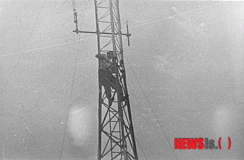 1975년 4월29일 월맹군에 대한 항복 전야에 사이공 주재 미 대사관의 송신탑에서 전선을 절단하고 있다.