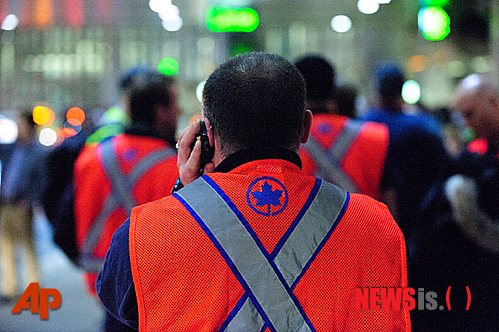 【토론토=AP/뉴시스】23일 캐나다 토론토 피어슨 국제공항에서 수하물 담당 직원이 휴대전화로 누군가와 통화를 하고 있다. 전날 오후부터 시작된 파업으로 수백명의 탑승한 승객들이 비행기에서 내려 대합실로 돌아갔고, 항공편 여러 편이 지연됐다.