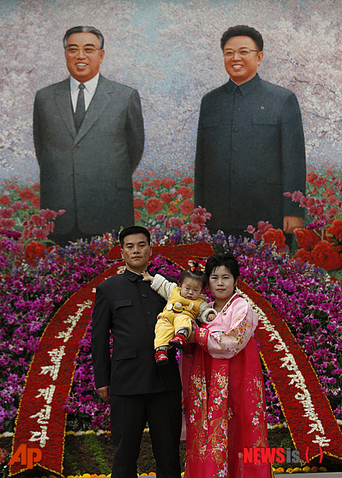 【평양=AP/뉴시스】북한 평양에서 김일성 주석 탄생 100주년을 맞아 김일성화 꽃 전시에서 한 가족이&nbsp; 김일성 주석과 김정일 국방위원장의 초상화 앞에서 사진을 찍기 위해 포즈를 취하고 있다. 