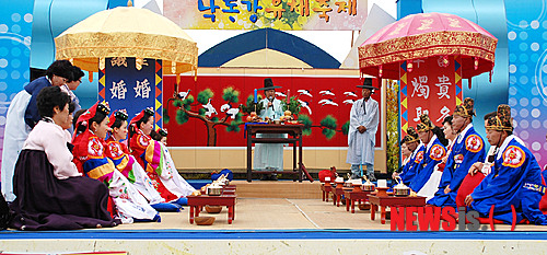 【창녕=뉴시스】안지율 기자 = 19일 경남 창녕군과 새마을운동 창녕군지회는 오는 21일 제7회 낙동강 유채축제를 맞아 남지 체육공원 유채꽃밭에서 다문화 가정 4쌍에 대해 합동 전통혼례식을 올린다. 사진은 지난해 유채축제 때 4쌍의 다문화 가정이 전통 혼례식을 올리고 있다. (사진=창녕군 제공)&nbsp; photo@newsis.com 