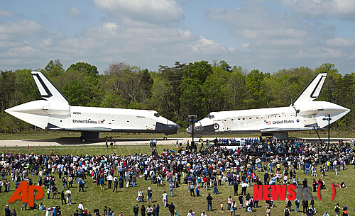 【워싱턴=AP/뉴시스】미국 버지니아주(州) 챈틸리에 있는 스미소니언박물관의 스티븐 F. 우드바-헤이지 센터에서 19일(현지시간) 열리는 이·취임식 전 우주왕복선 엔터프라이스호(왼쪽)와 디스커버리호가 마주 보고 서 있다. 스미소니언박물관이 미 항공우주국(NASA)을 통해 공개했다. 디스커버리호가 이 센터에서 우주탐험의 업적을 기념하고 30년의 우주왕복 프로그램을 대표하는 유물로서 임무를 마친 엔터프라이스호를 대신할 것이다.